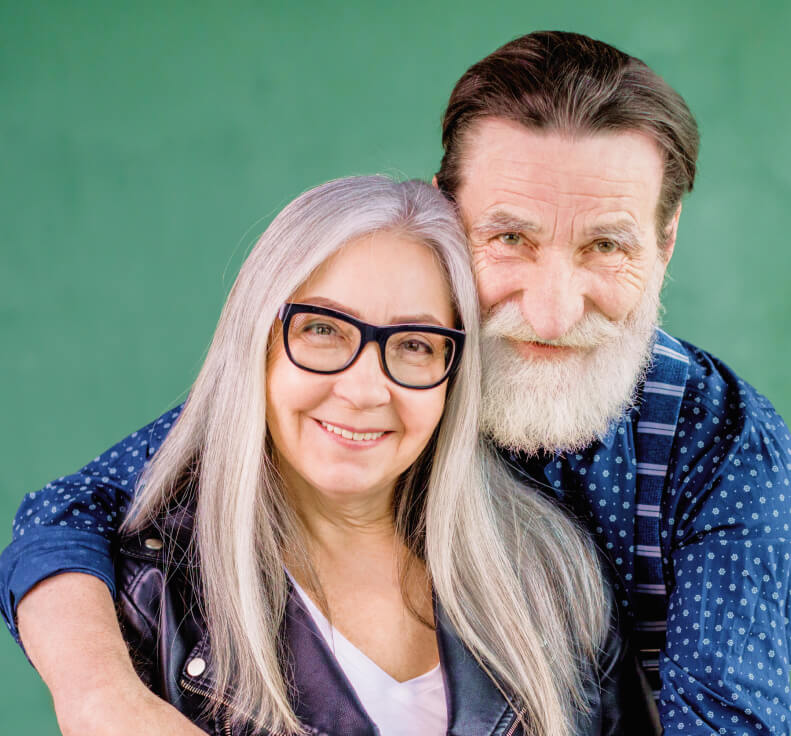 Elderly couple smiling and leaning together