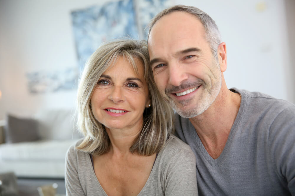 Middle-aged couple smiling indoors