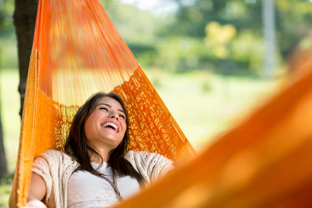 Young woman laughing in a hammock
