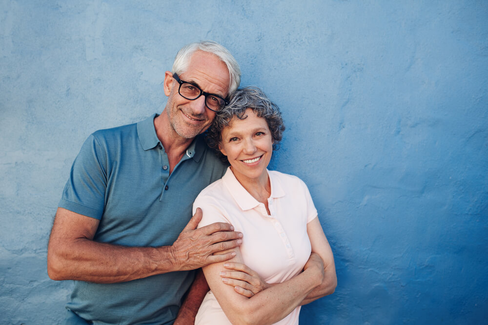 Elderly couple smiling and leaning against each other