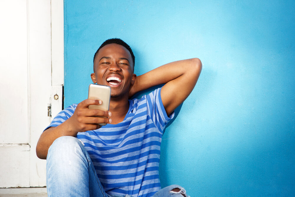 Young man laughing and holding his phone